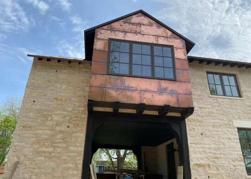 Copper metal panel facade on a stone building for Skylight Installation in Little River